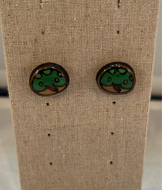 A pair of handmade wooden earrings featuring a green snake design. 